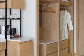 a room with a white robe and a black shelf
