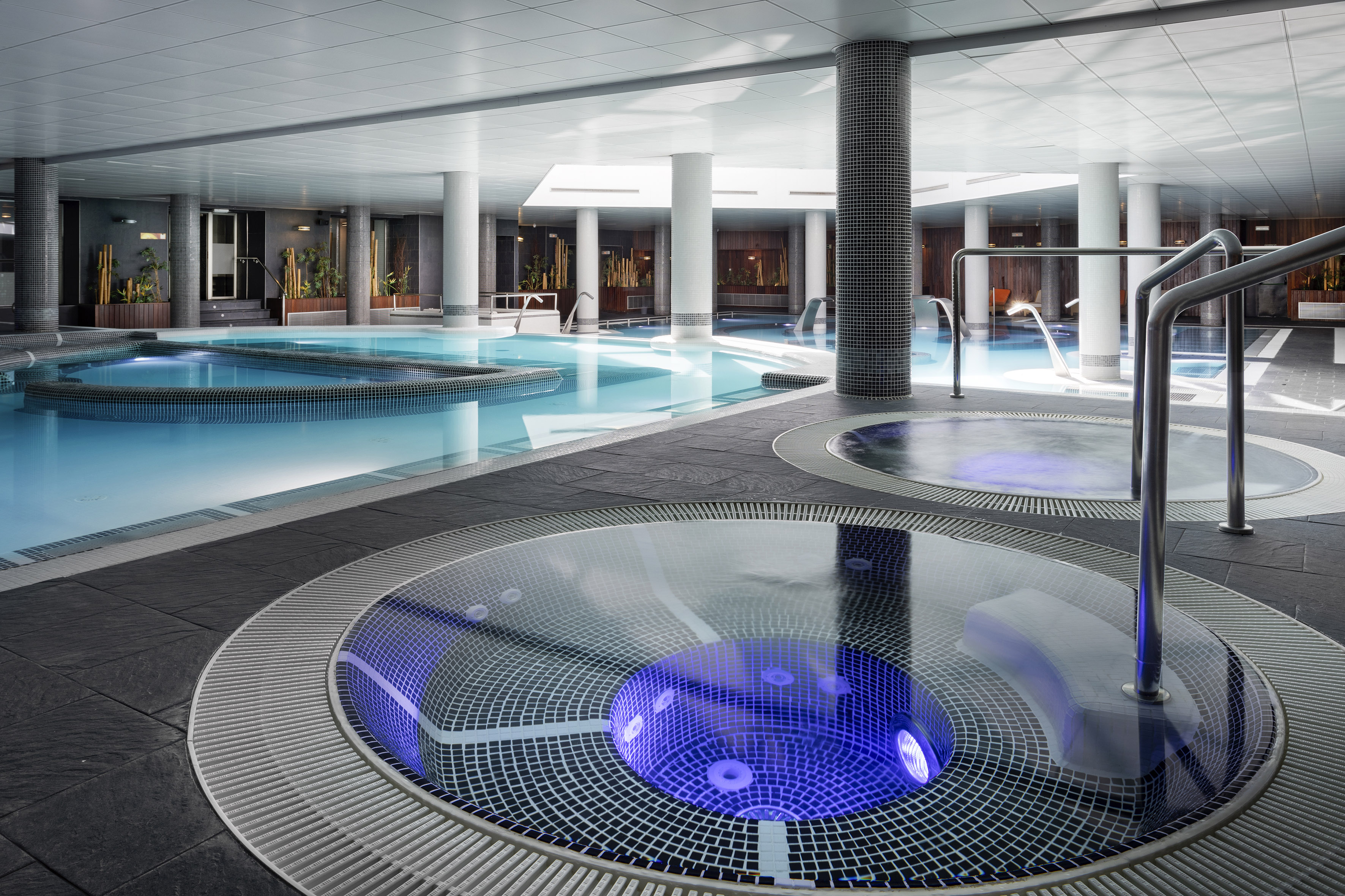 a swimming pool with a round jacuzzi