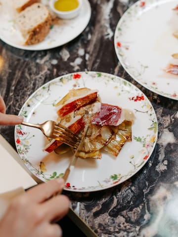 a person cutting food on a plate