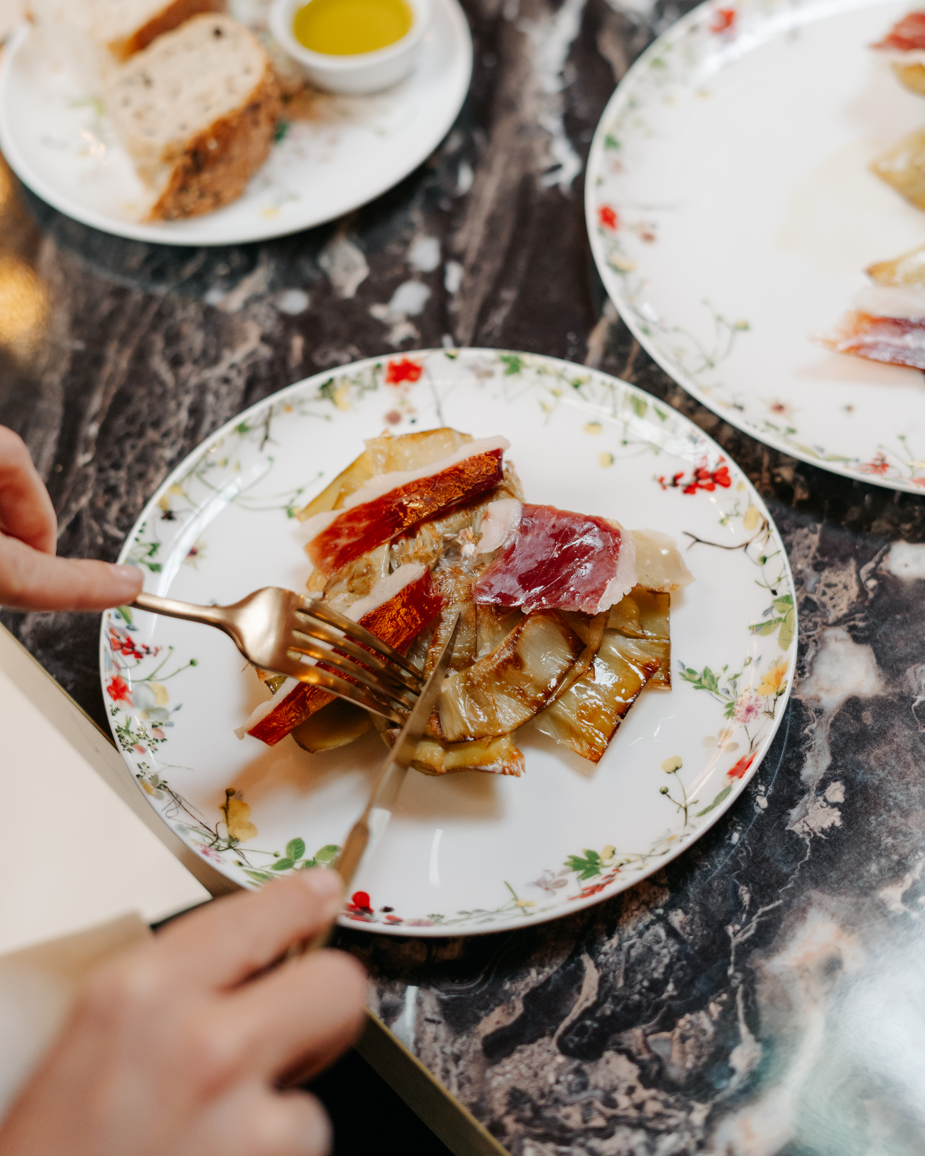 a person cutting food on a plate