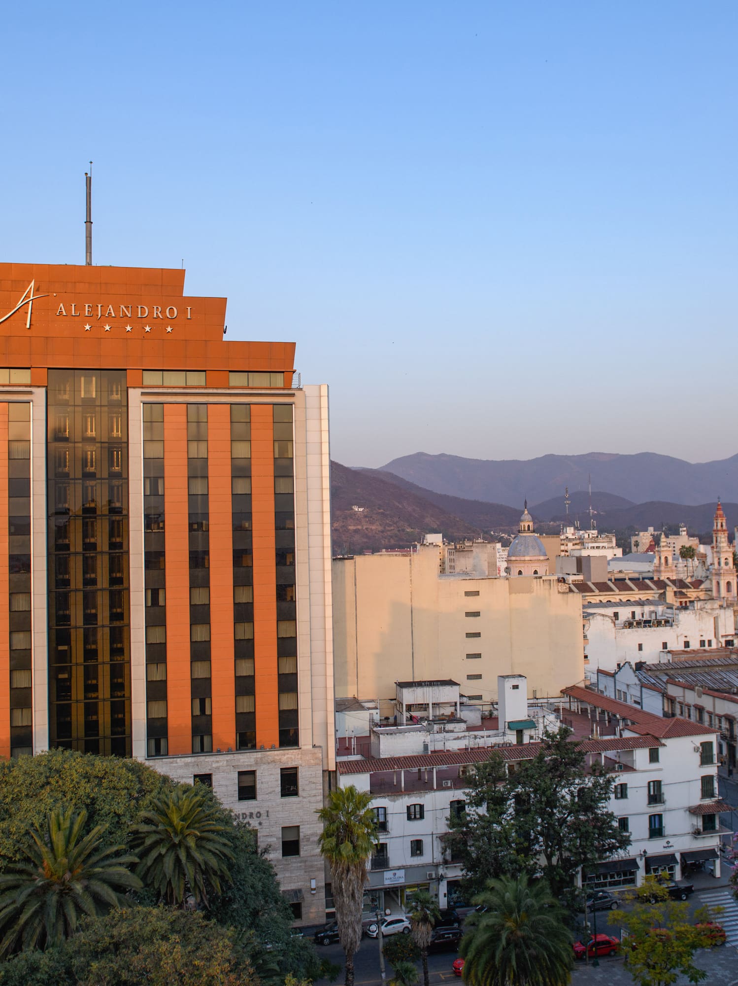 a building with trees and mountains in the background