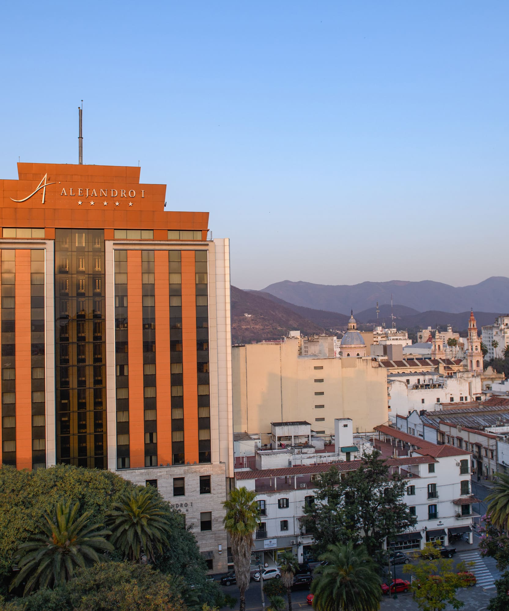 a building with trees and mountains in the background