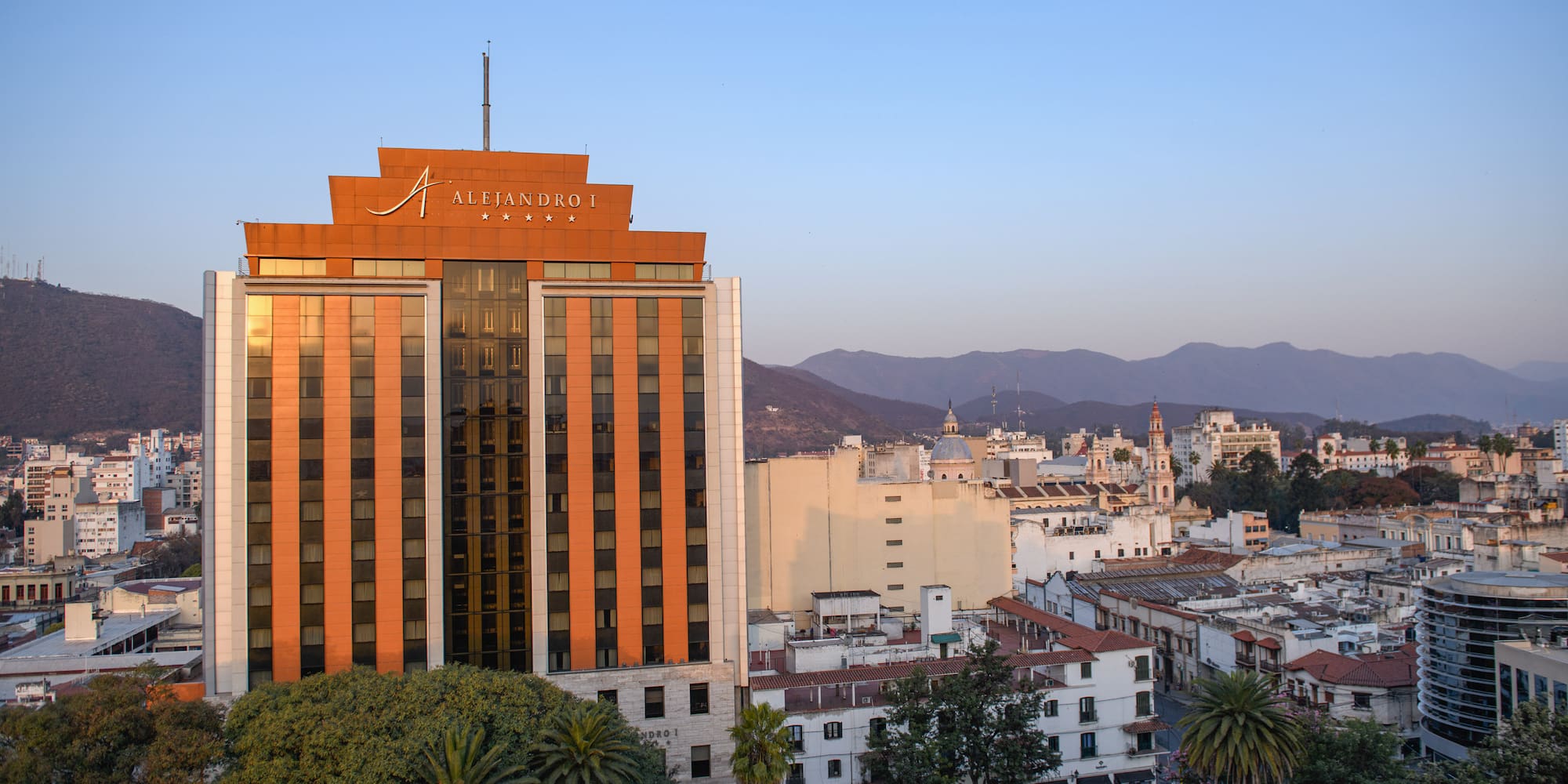 a building with trees and mountains in the background