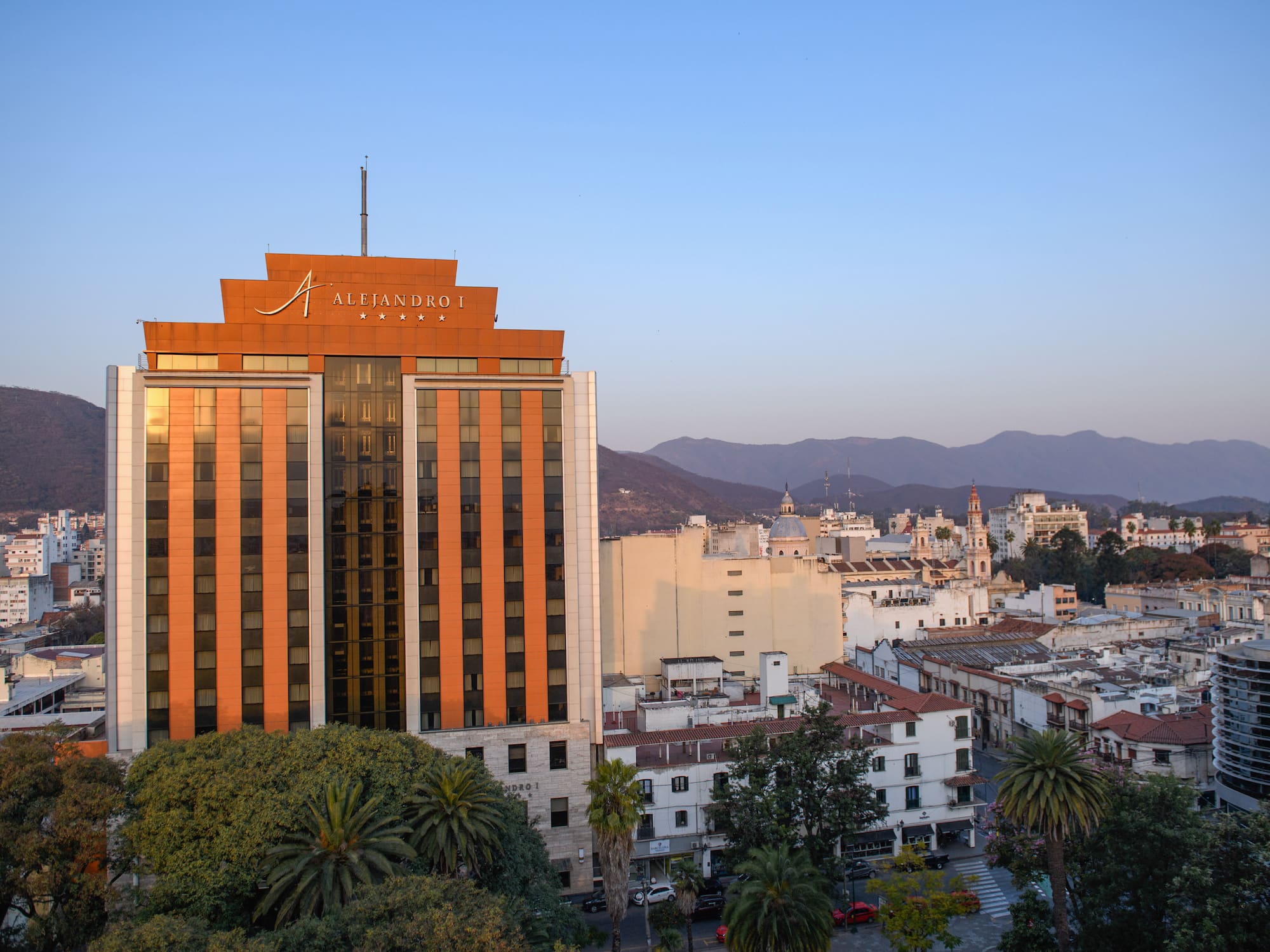a building with trees and mountains in the background