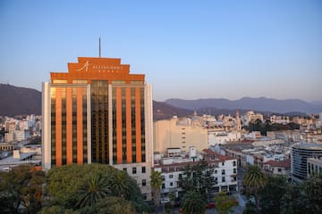 a building with trees and mountains in the background