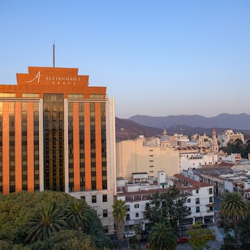a building with trees and mountains in the background