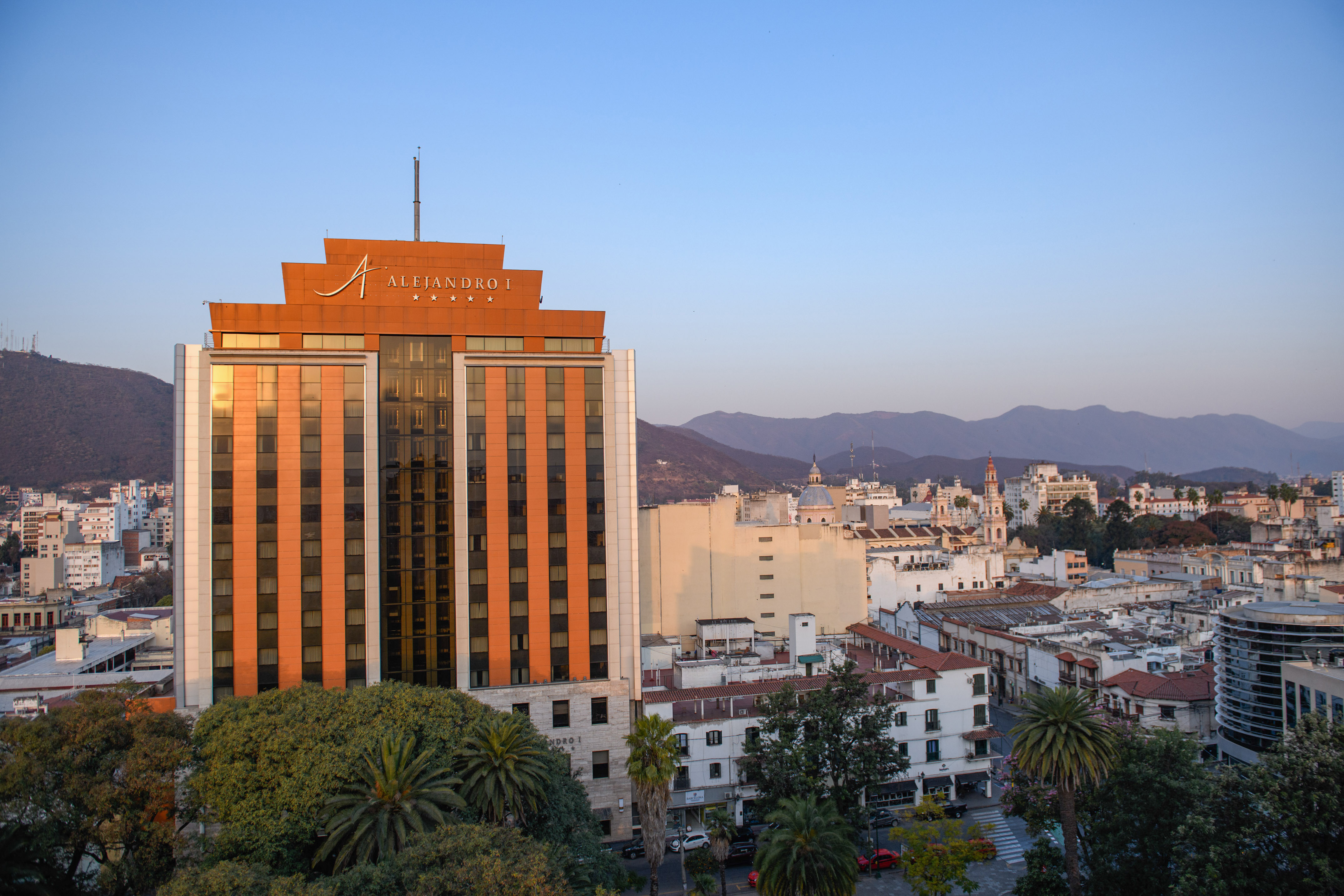 a building with trees and mountains in the background