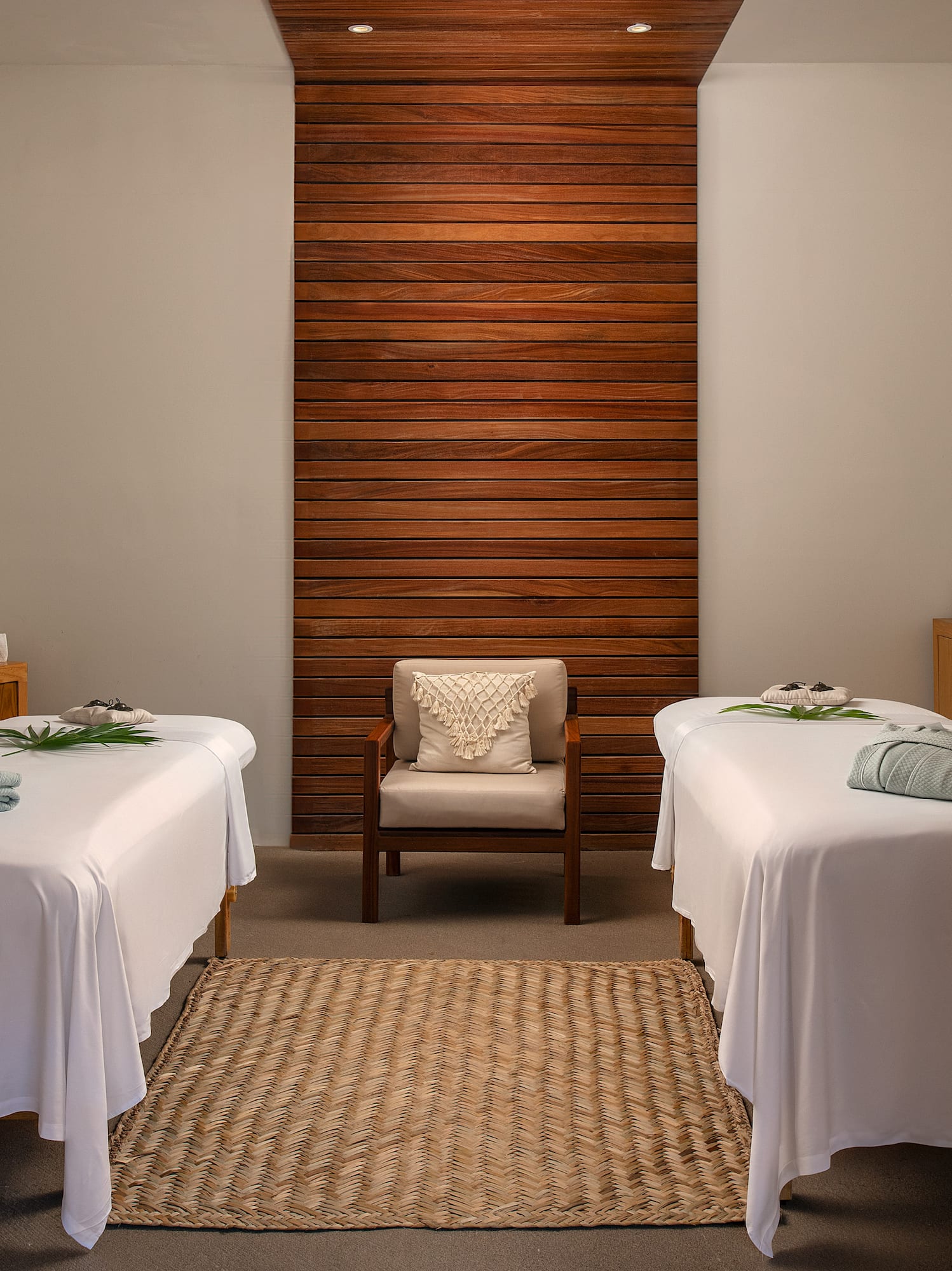 a room with white beds and a chair