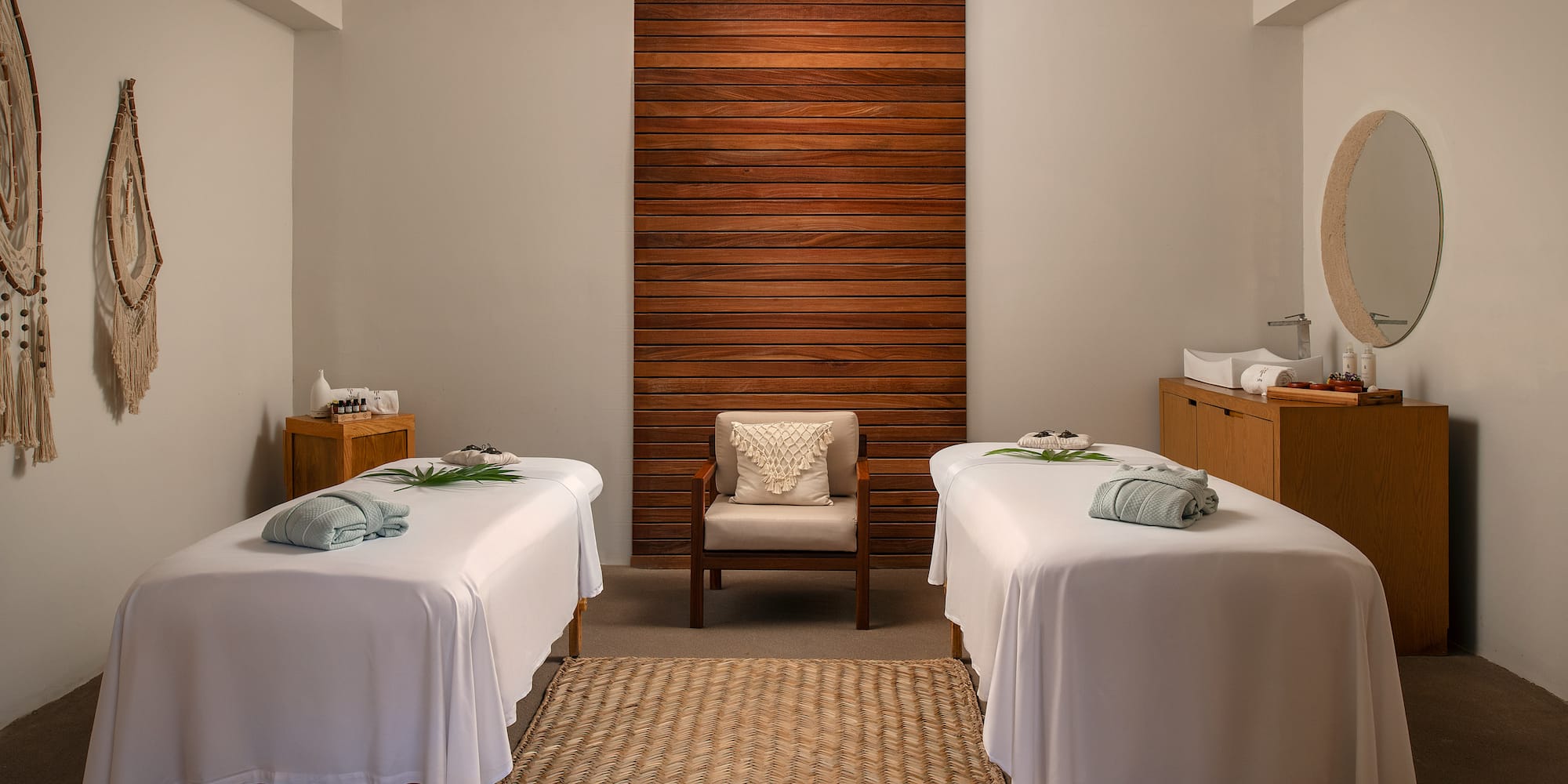 a room with white beds and a chair