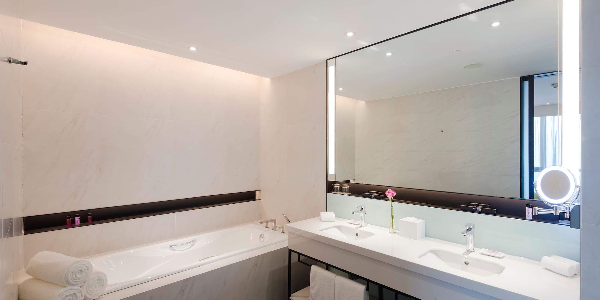 a bathroom with a large mirror and a tub