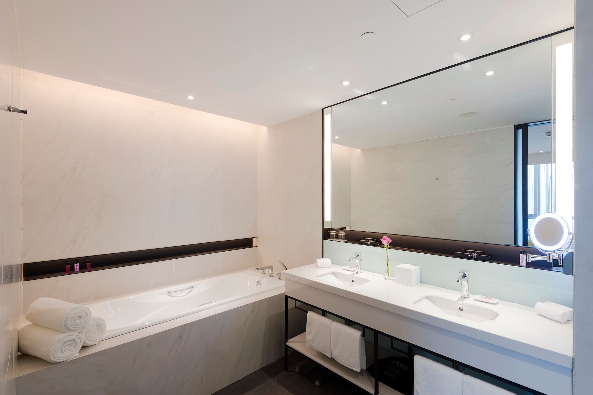 a bathroom with a large mirror and a tub