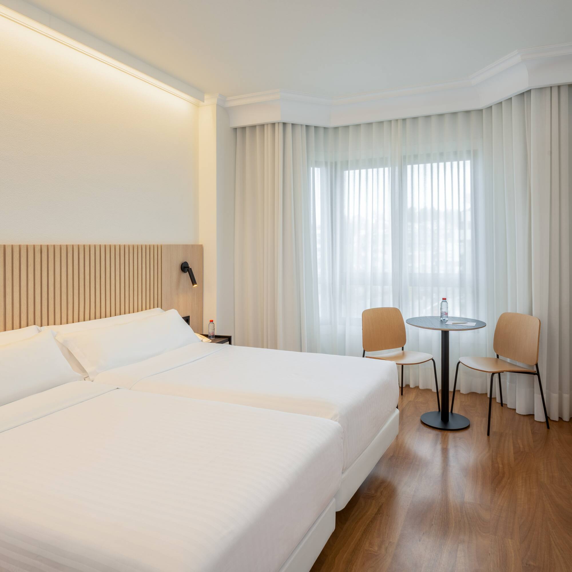 a room with two beds and a table