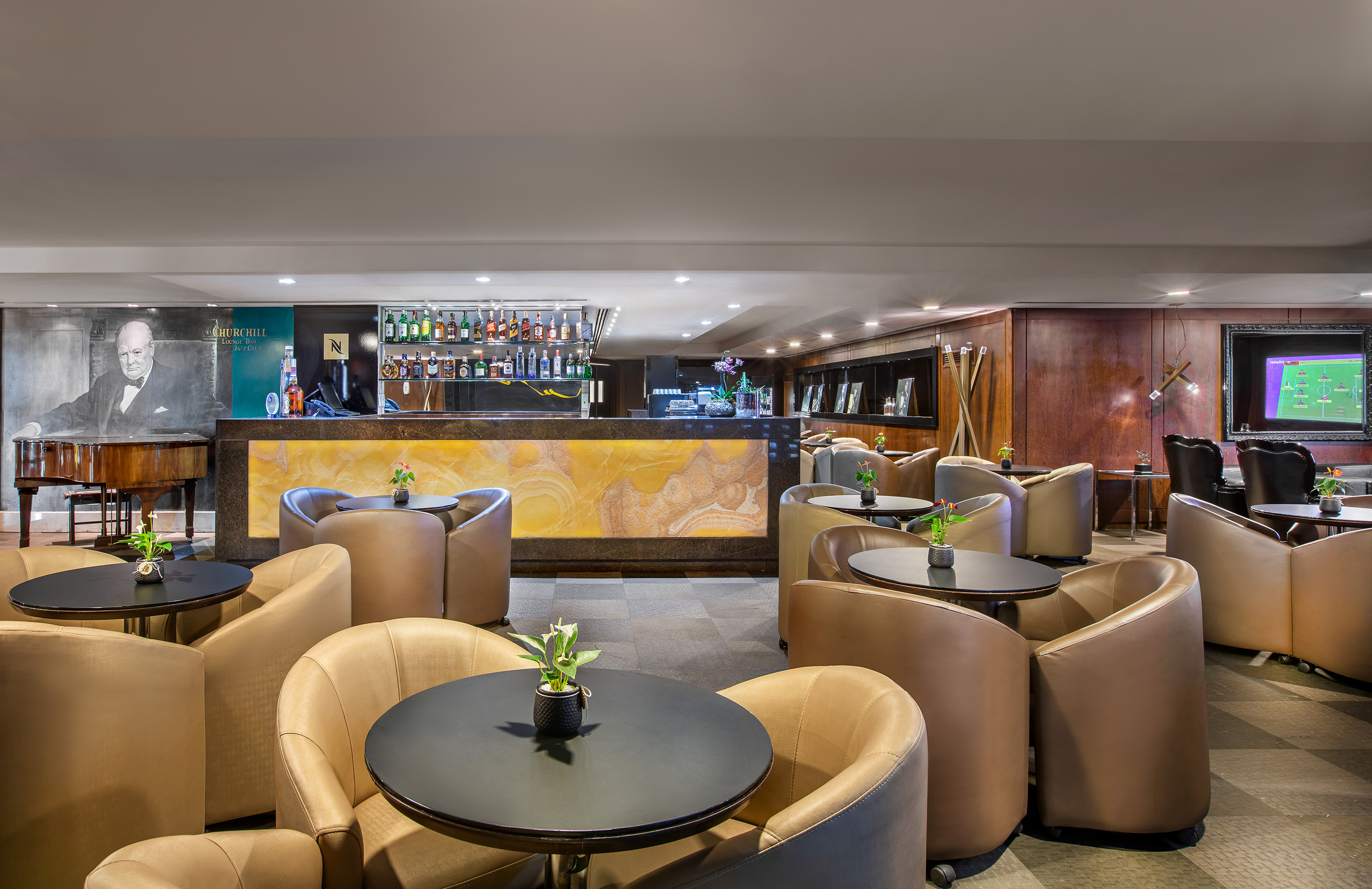 Churchill Lounge Bar: comfortable seating, grand piano, and illuminated bar.