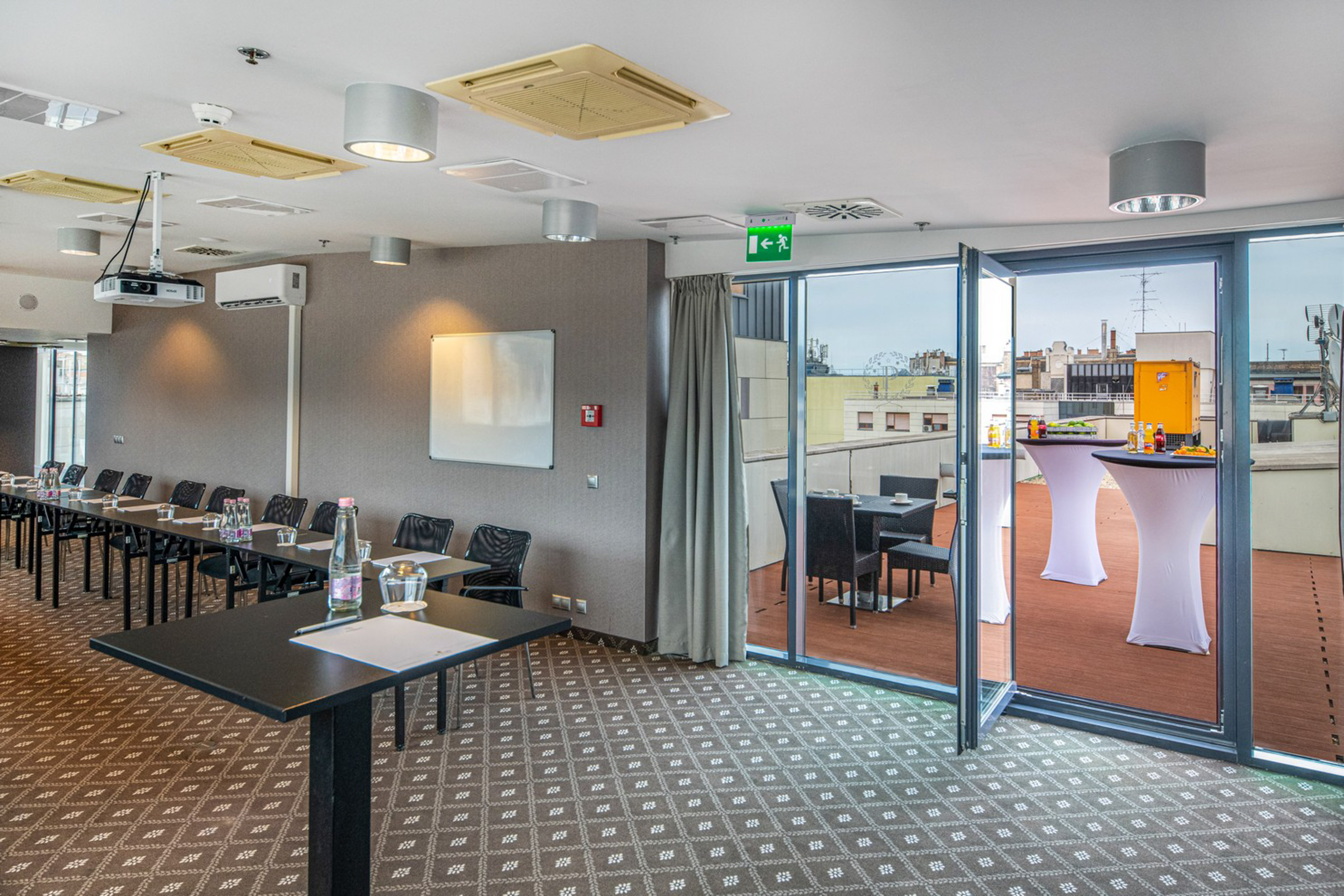 Modern conference room, projector, and rooftop terrace setup for corporate events.