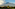 a mountain with trees and clouds