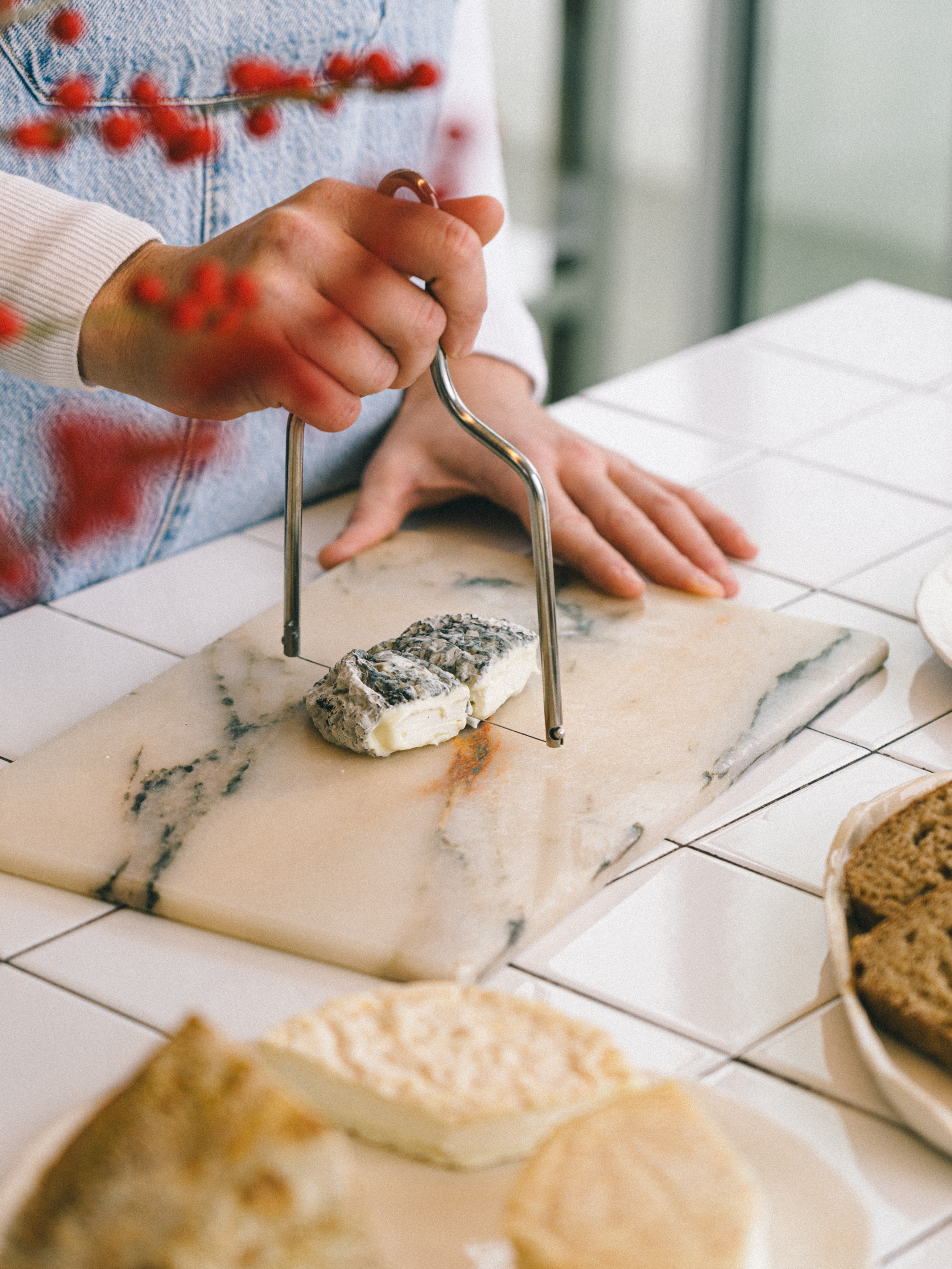 a person cutting a piece of cheese