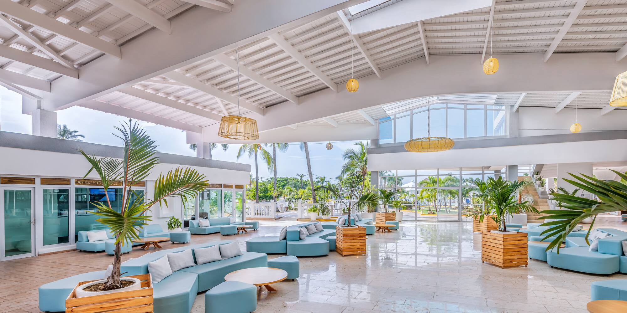 a large room with blue couches and plants