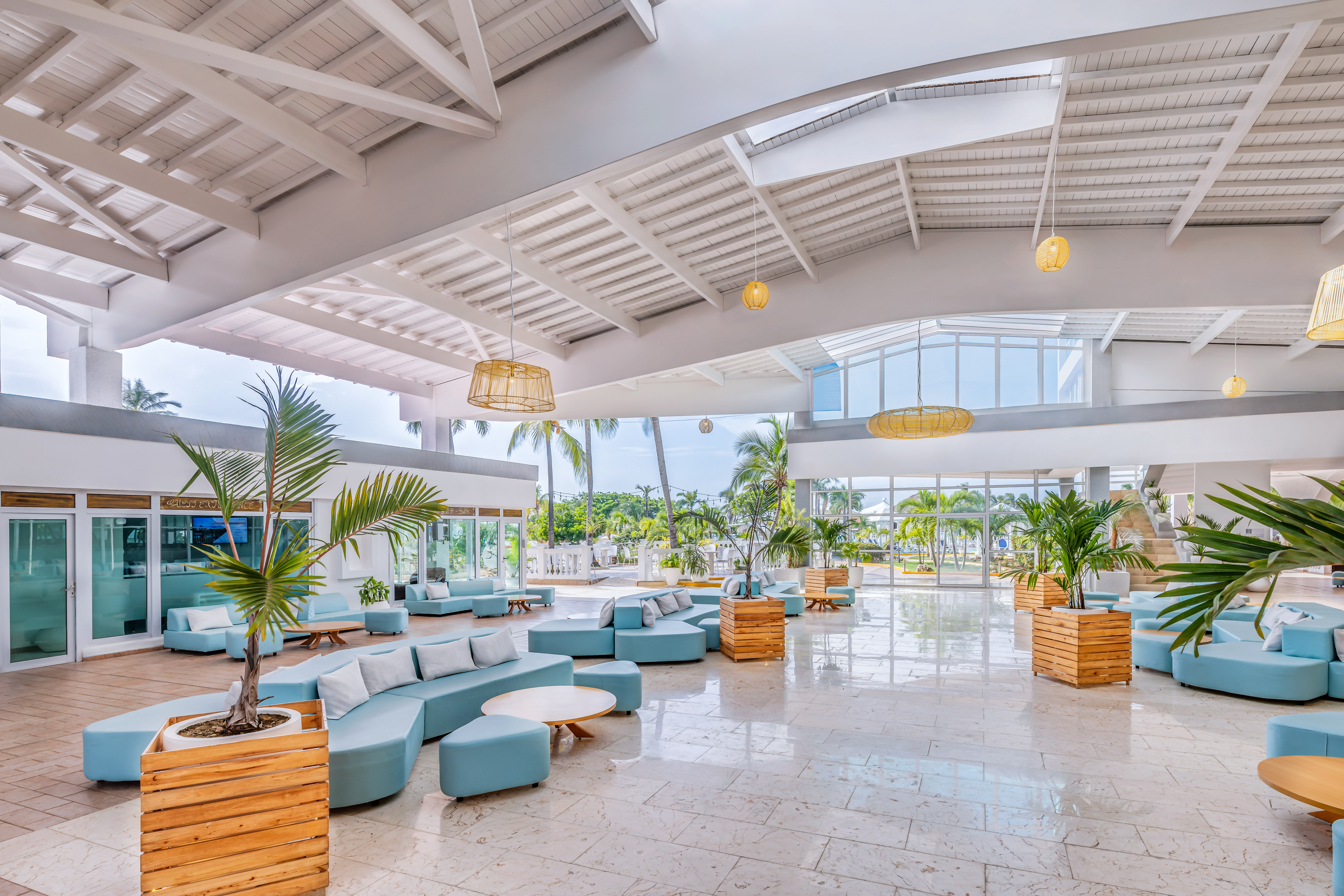 a large room with blue couches and plants