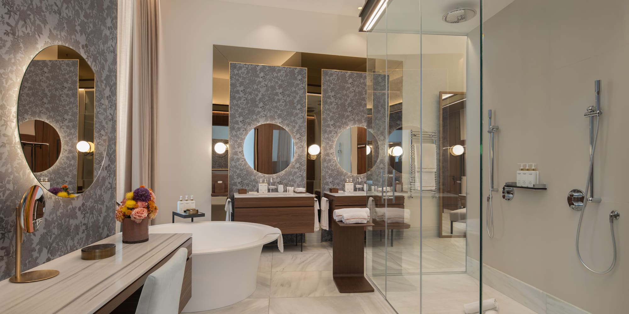 Modern luxury bathroom with freestanding tub, double vanity, and glass shower.