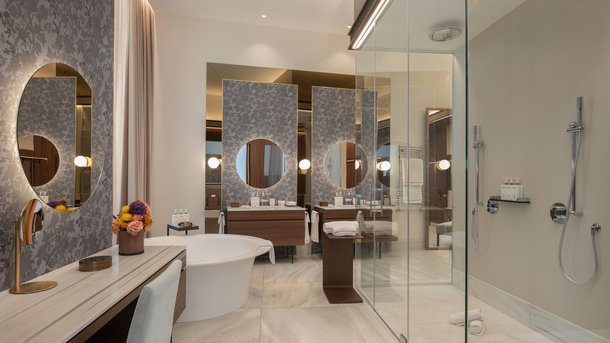 Modern luxury bathroom with freestanding tub, double vanity, and glass shower.