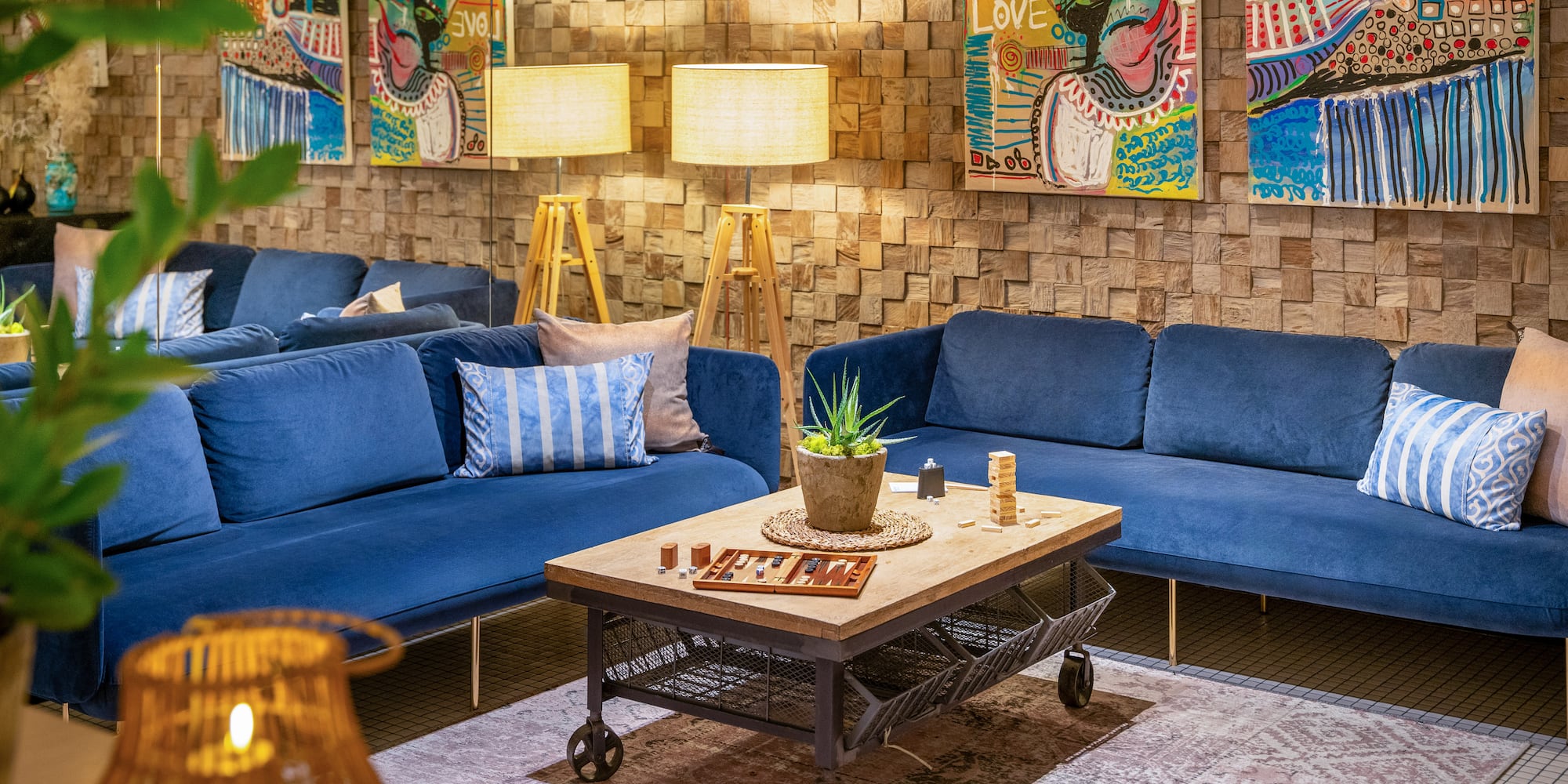 a room with blue couches and art on the wall