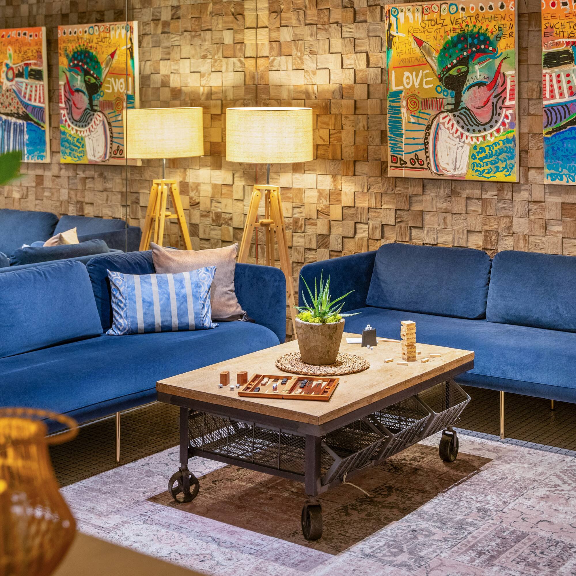 a room with blue couches and art on the wall
