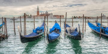 a row of boats in water with blue covers