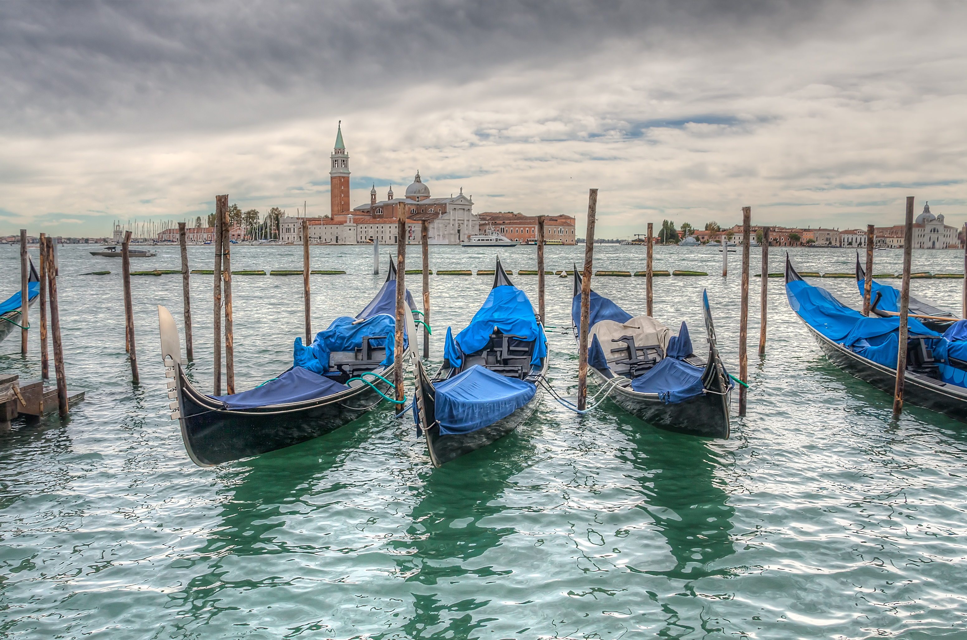 a row of boats in water with blue covers