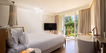 a bedroom with a television and a tub