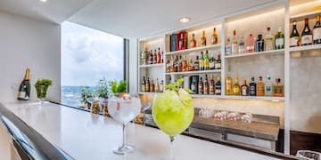 a two glasses of drinks on a bar