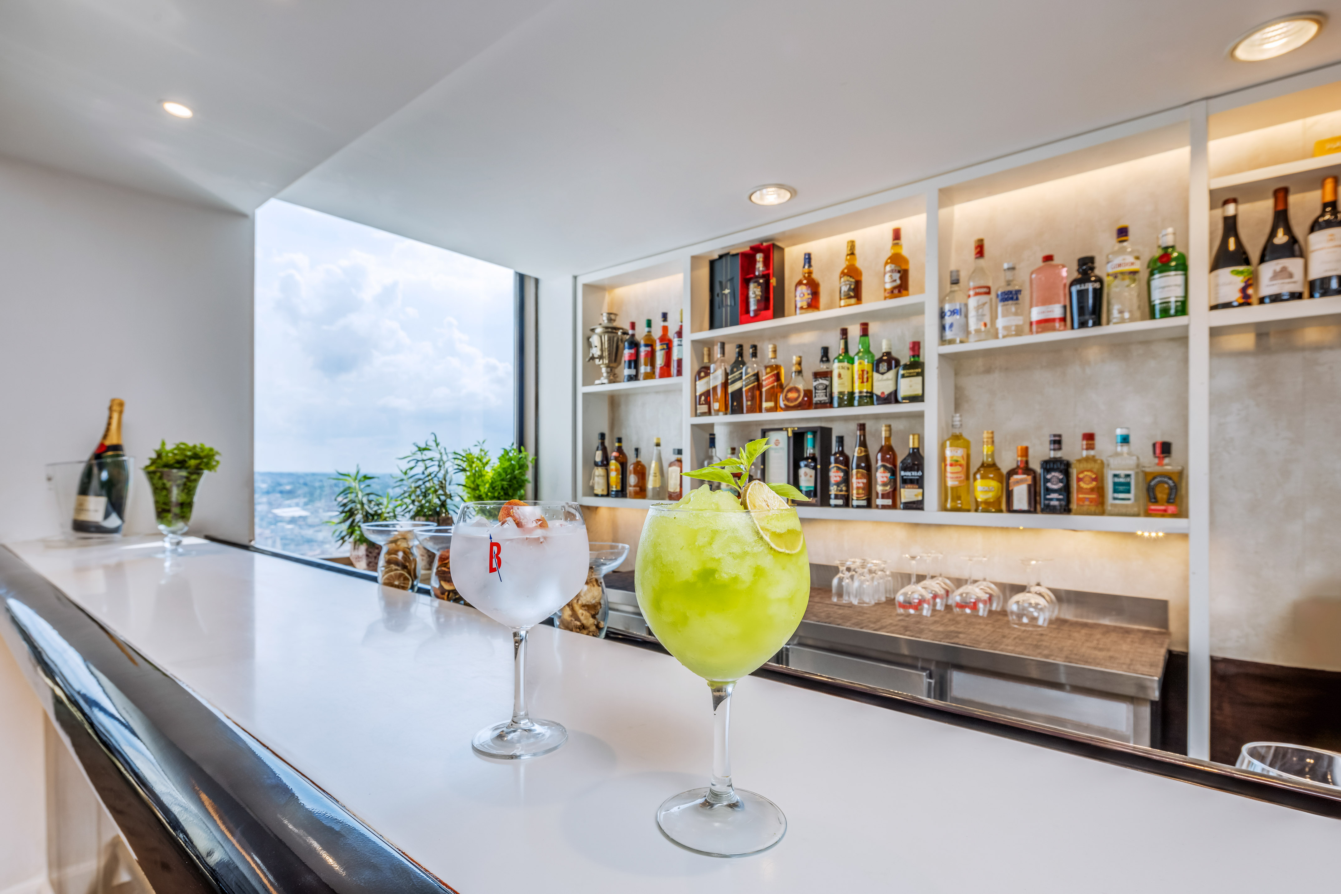 a two glasses of drinks on a bar