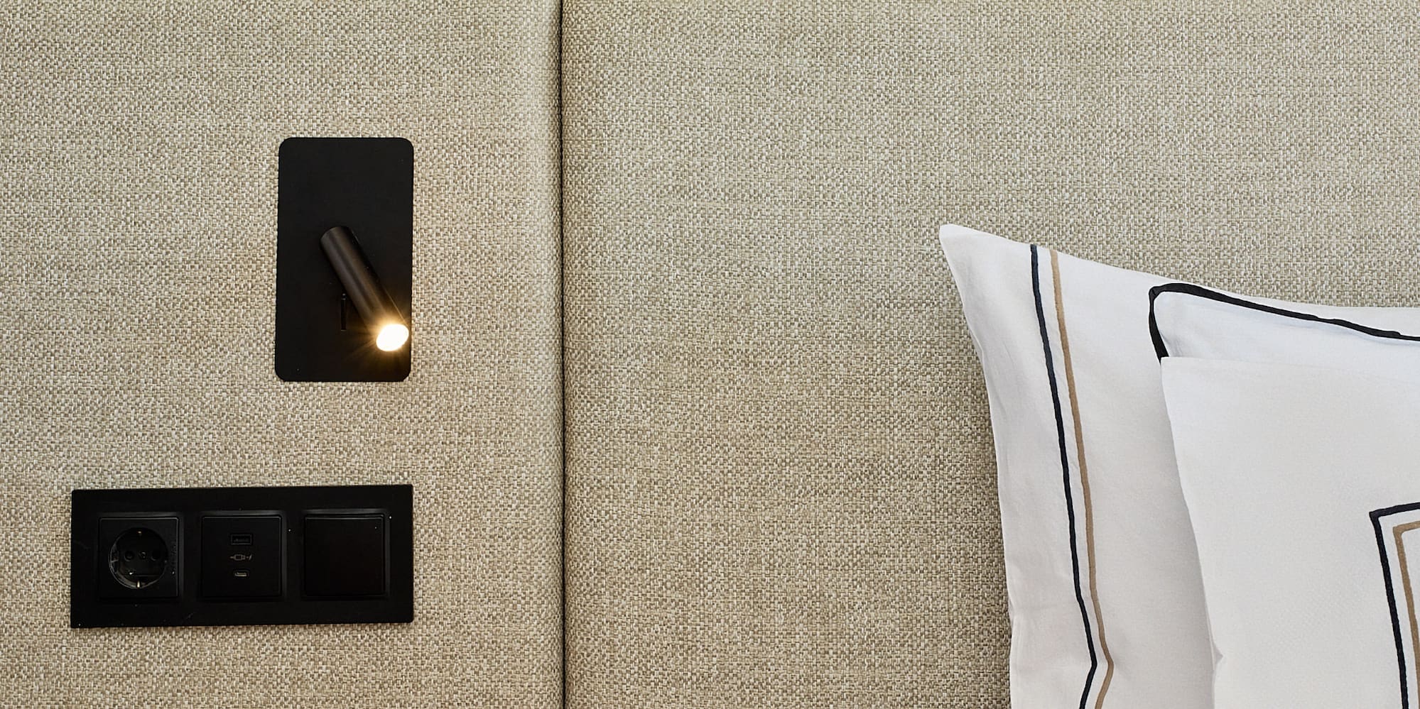 a bed with a light on the wall