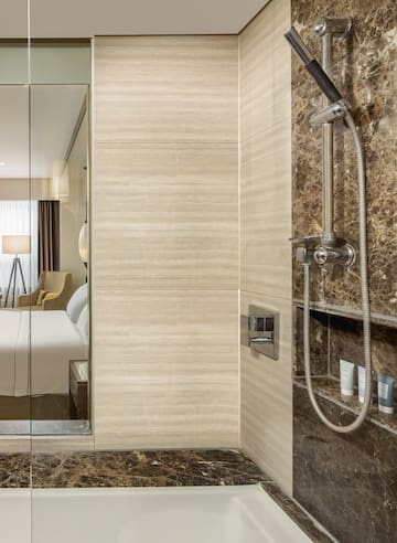 a shower with a shower head and a mirror