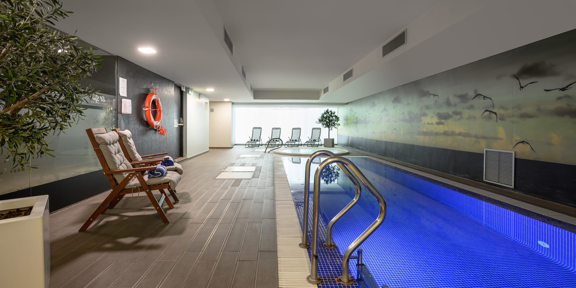 a swimming pool with chairs and a wall