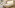 Spacious hotel bedroom with king bed, neutral decor, and balcony view of pine trees.