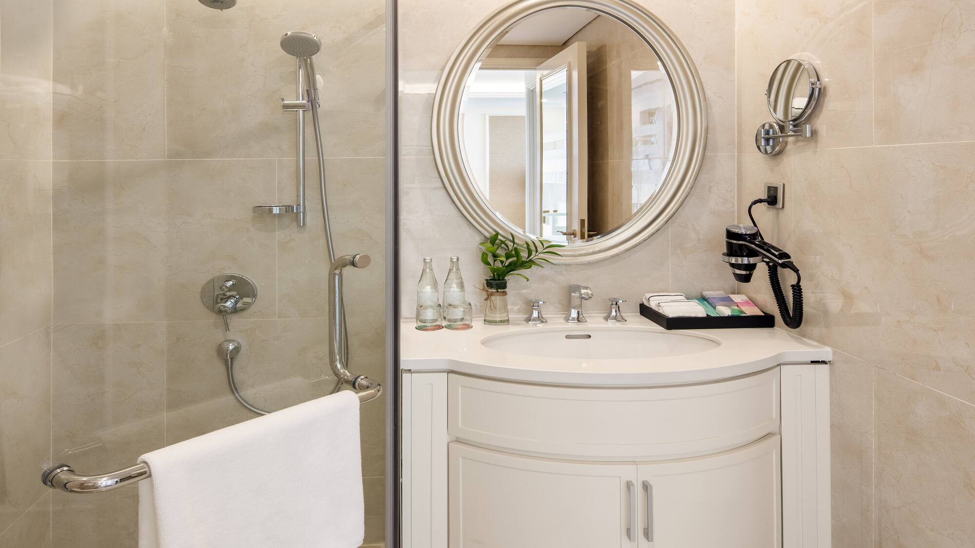 a bathroom with a round mirror and shower