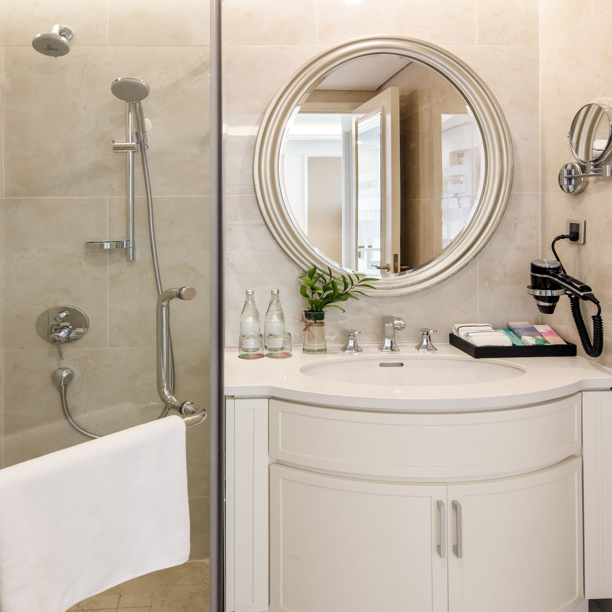a bathroom with a round mirror and shower