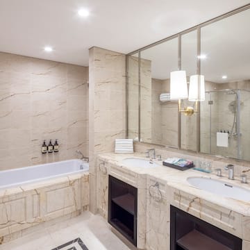 a bathroom with marble countertops and a tub