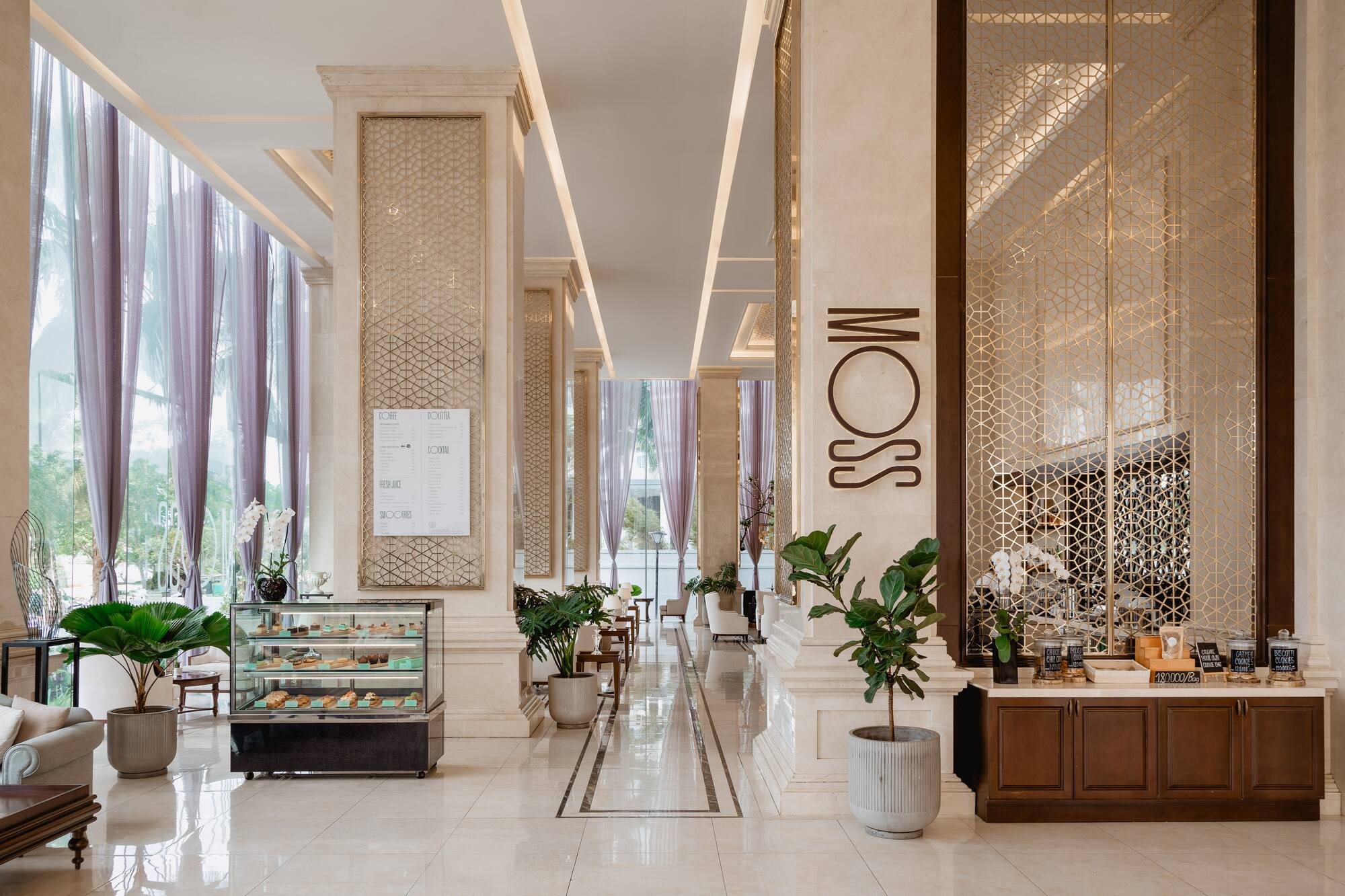 Upscale MOSS cafe interior with dessert case, drinks menu, and marble columns.