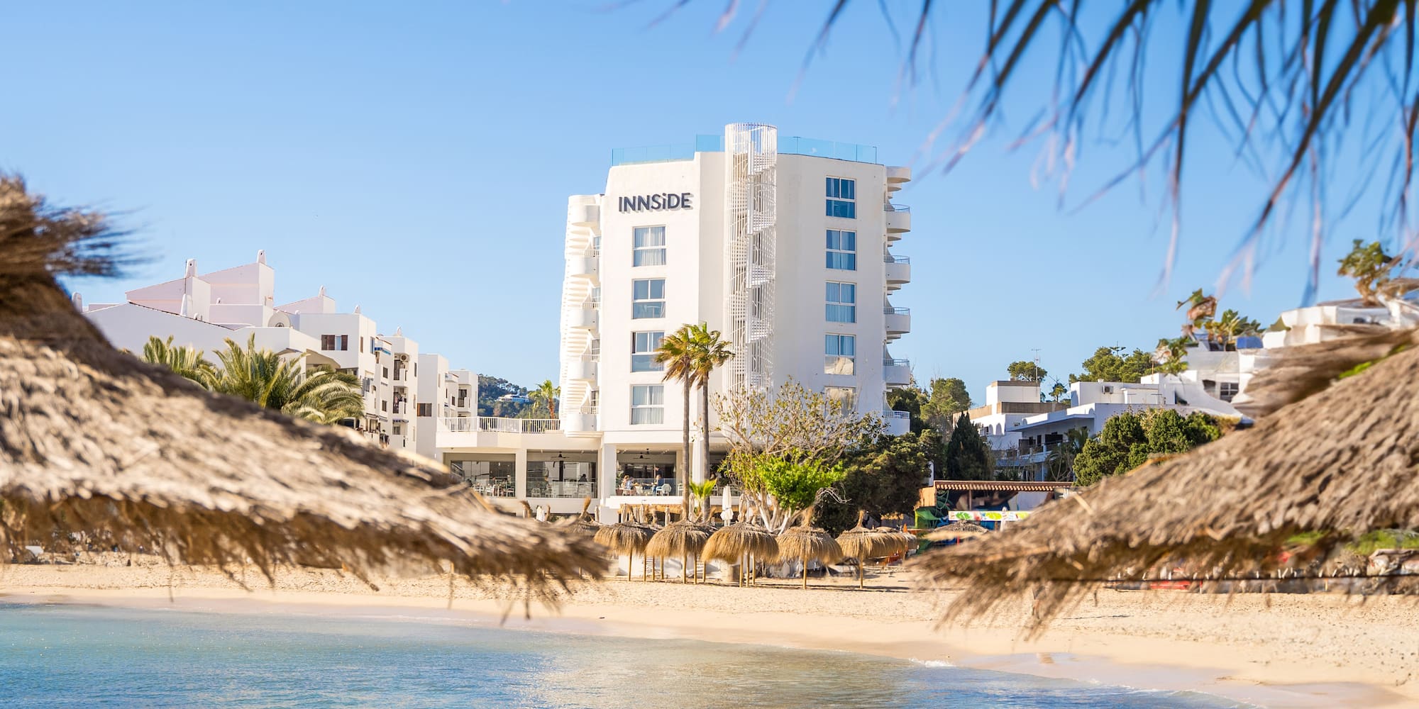 a beach with a building and palm trees