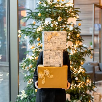 a person holding a stack of presents