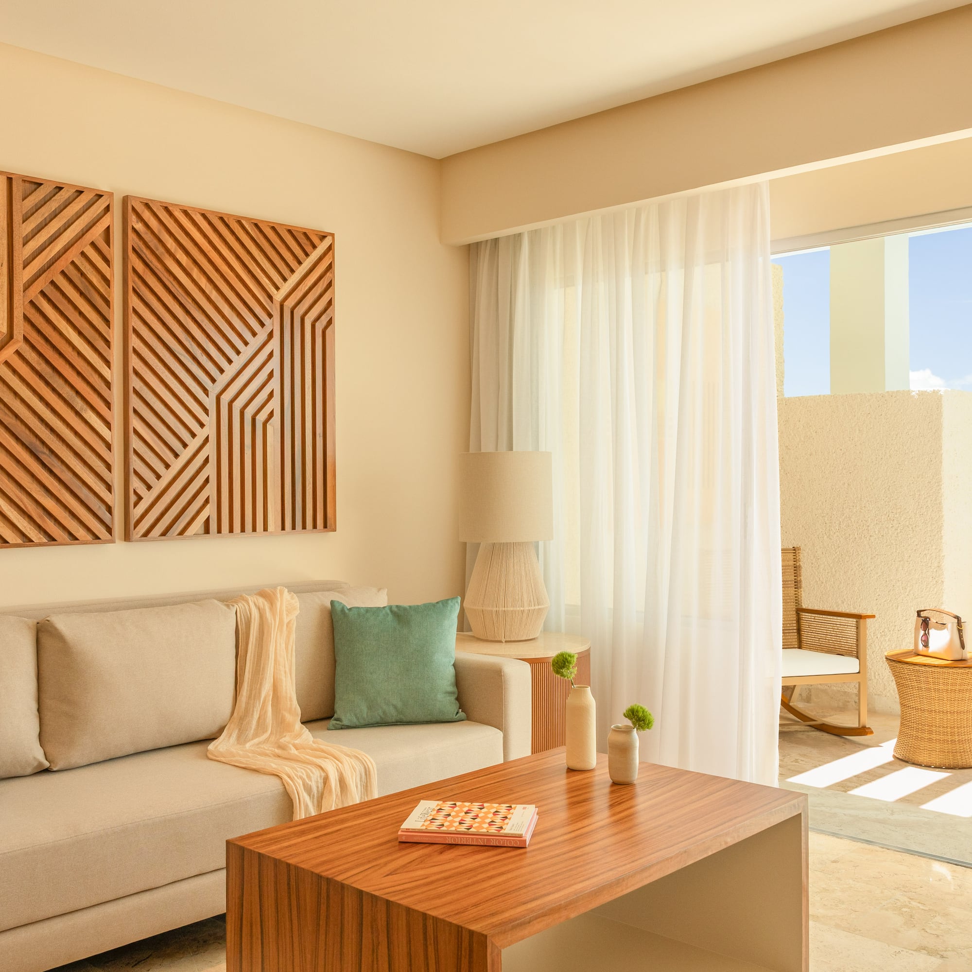 Modern living room with beige sofa, geometric wood art, and bright balcony.