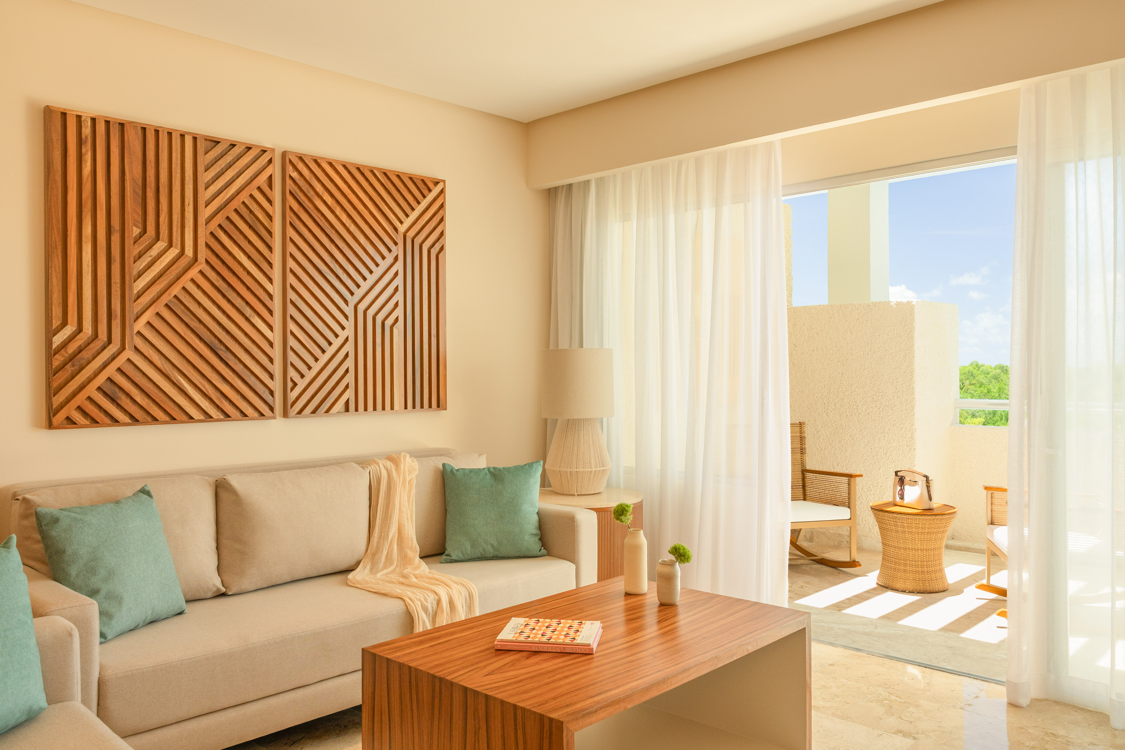 Modern living room with beige sofa, geometric wood art, and bright balcony.
