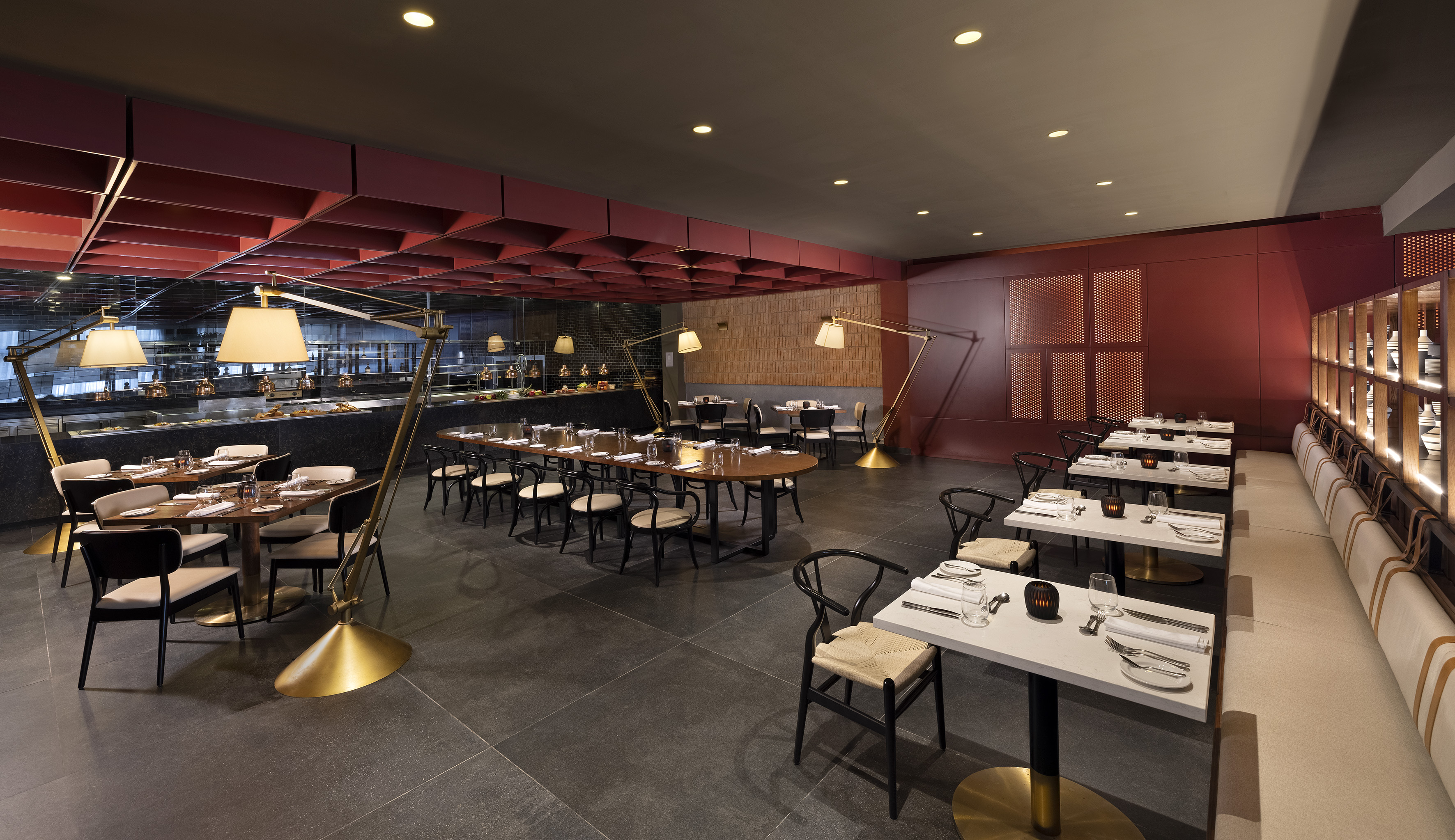 Modern restaurant interior with red accents, set dining tables, and buffet area.
