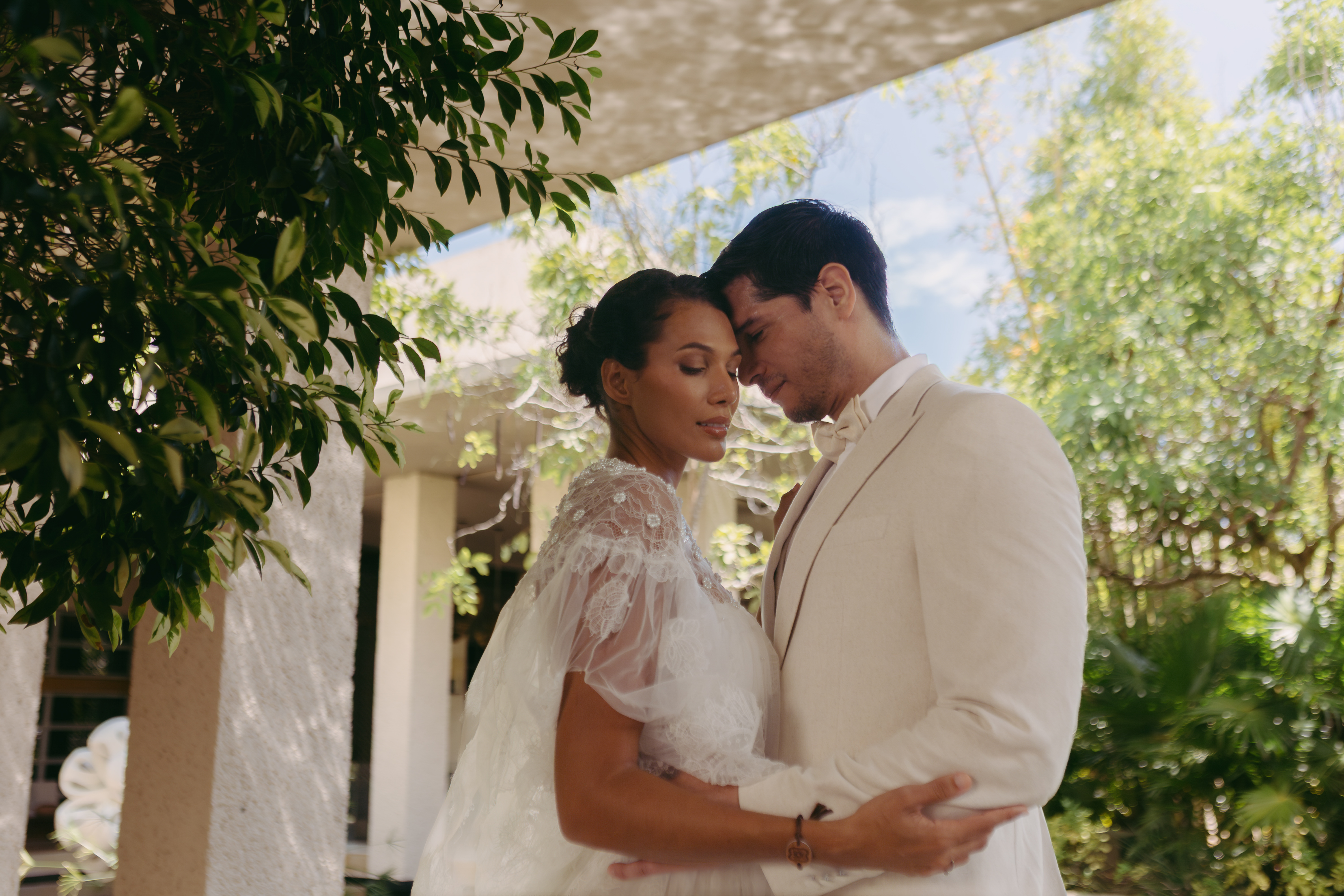 a man and woman in white suit holding each other