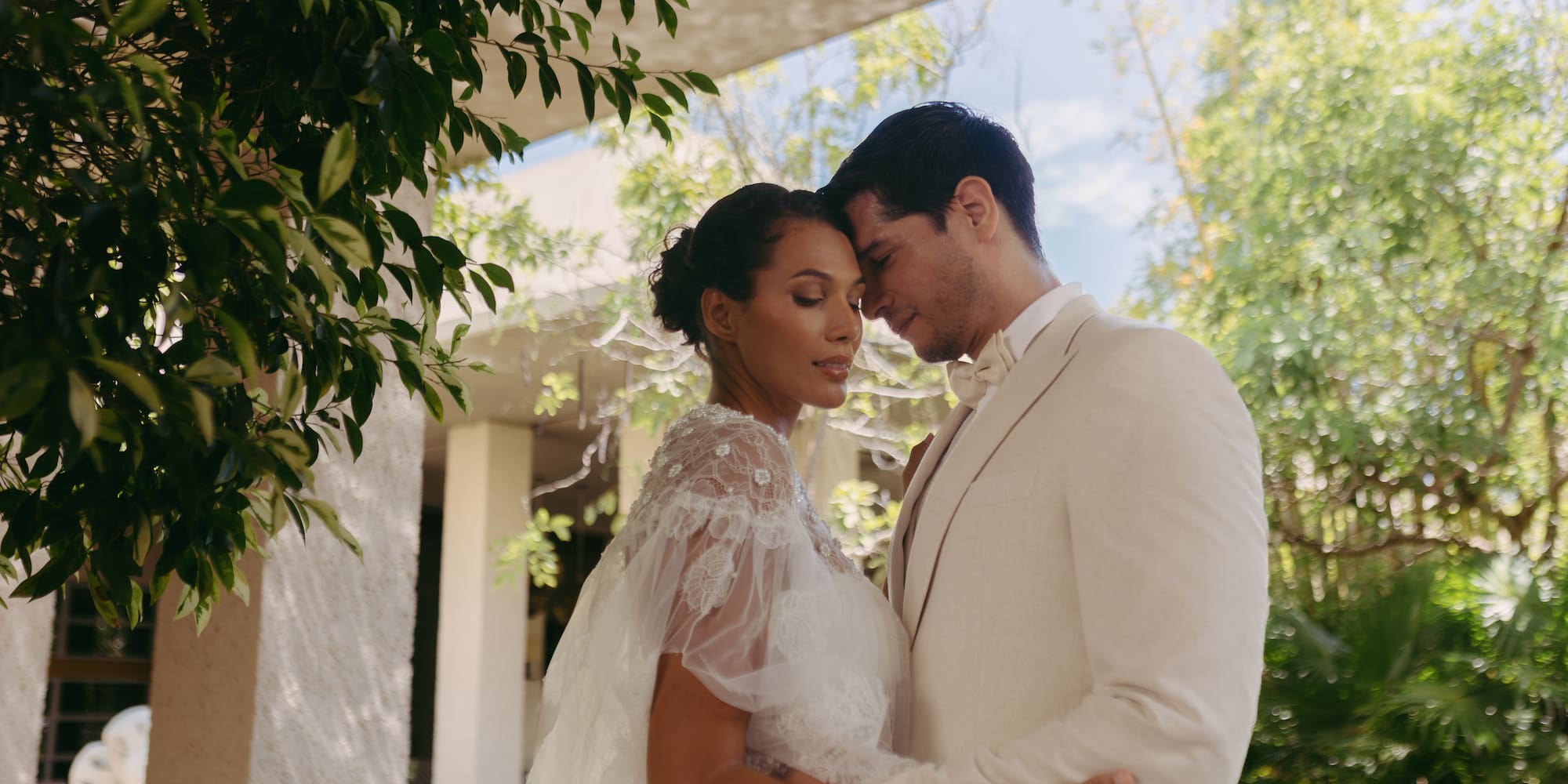 a man and woman in white suit holding each other