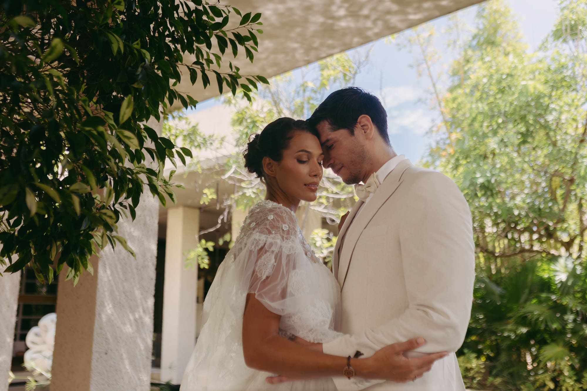 a man and woman in white suit holding each other