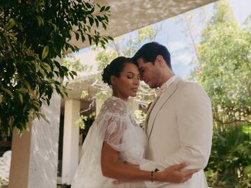 a man and woman in white suit holding each other