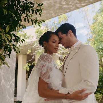 a man and woman in white suit holding each other