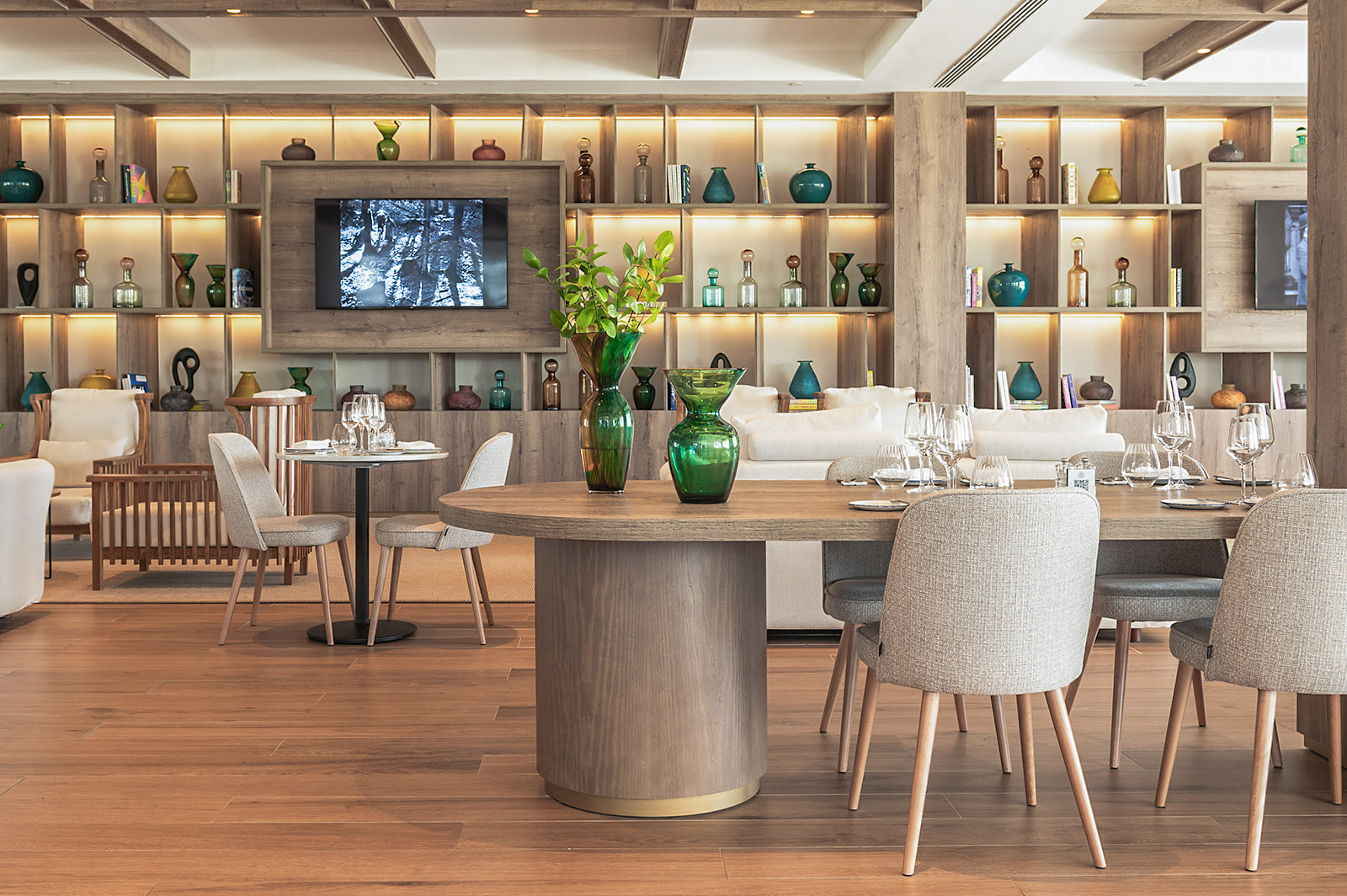 Modern hotel dining area with wooden tables, chairs, and stylish decor.